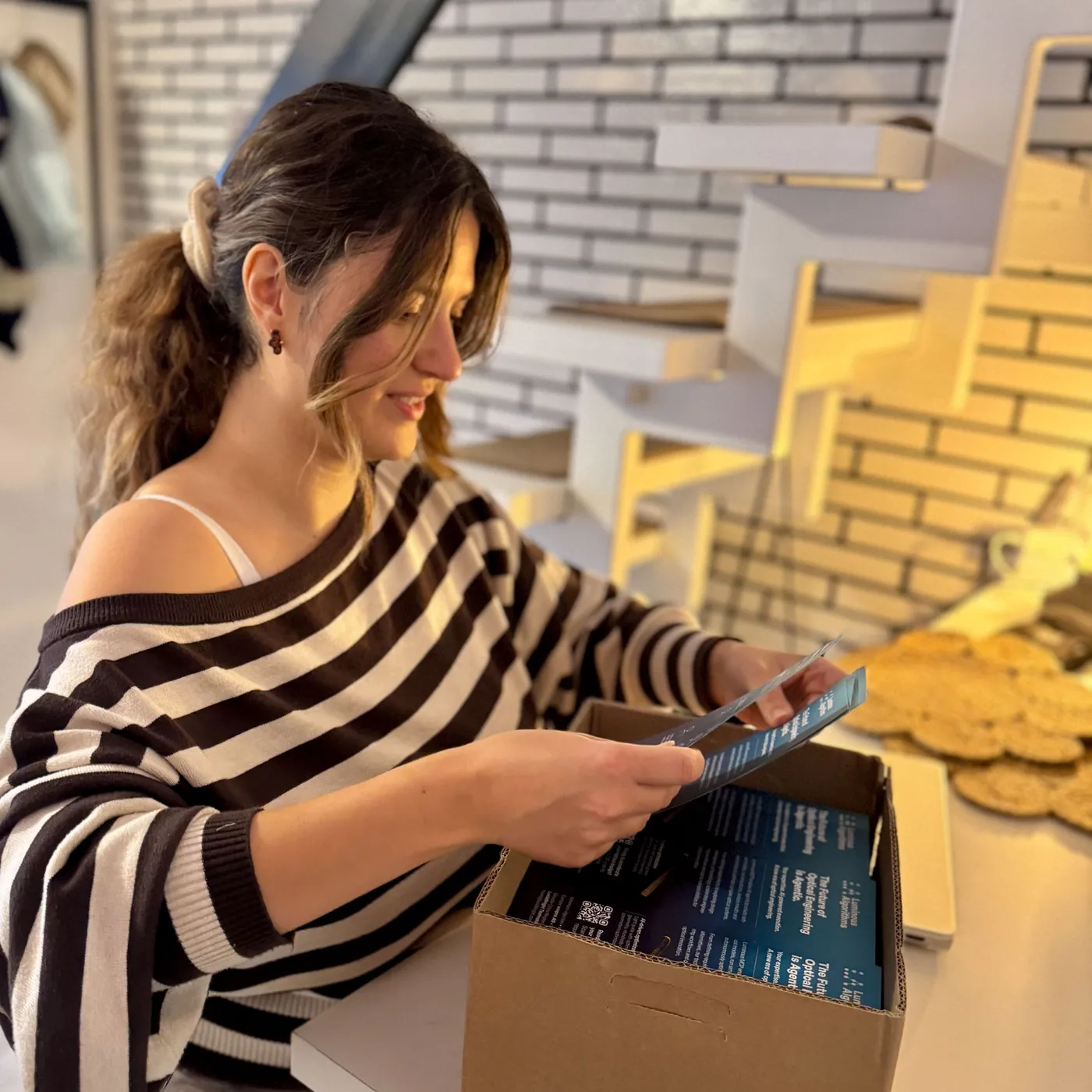 Martina Sofia Dörr prüft die frisch gedruckten Flyer für Luminous Algorithms vor dem Versand