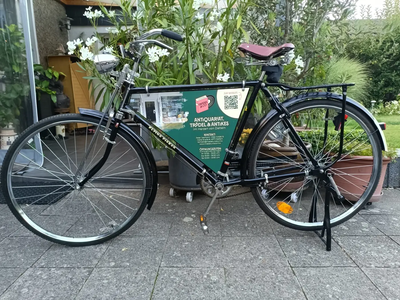 Werbeschild von Trödel & Co im Rahmen eines alten Fahrrads